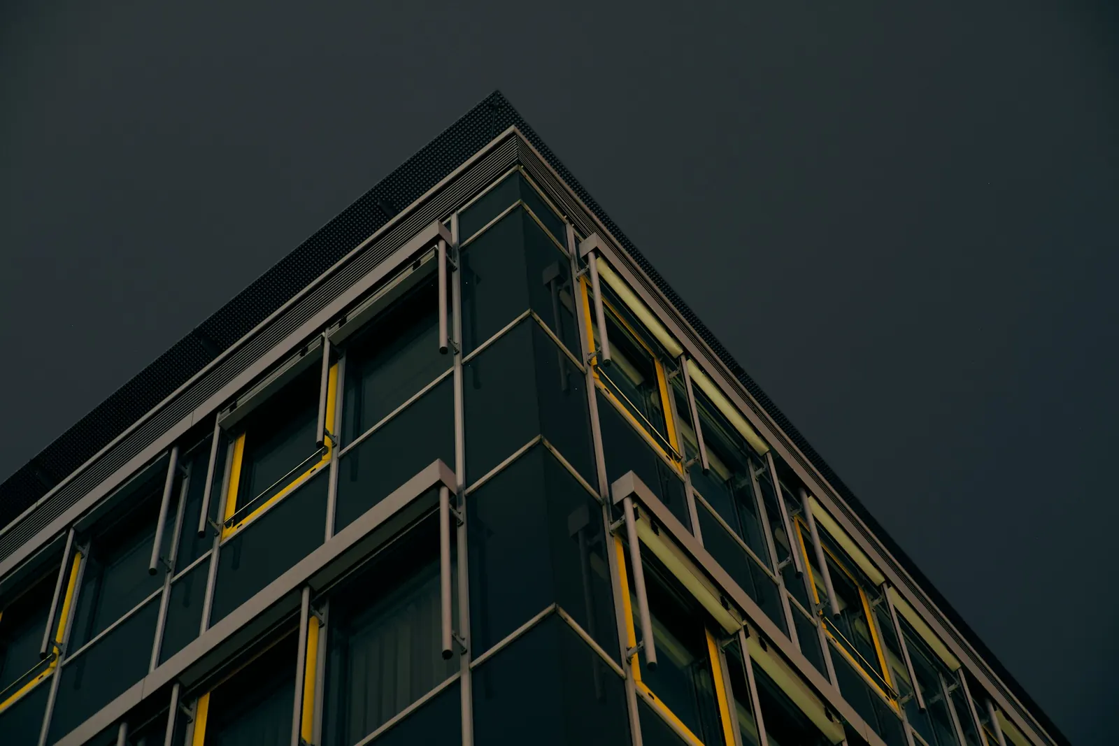 Fachada de edifício corporativo com linhas douradas à noite