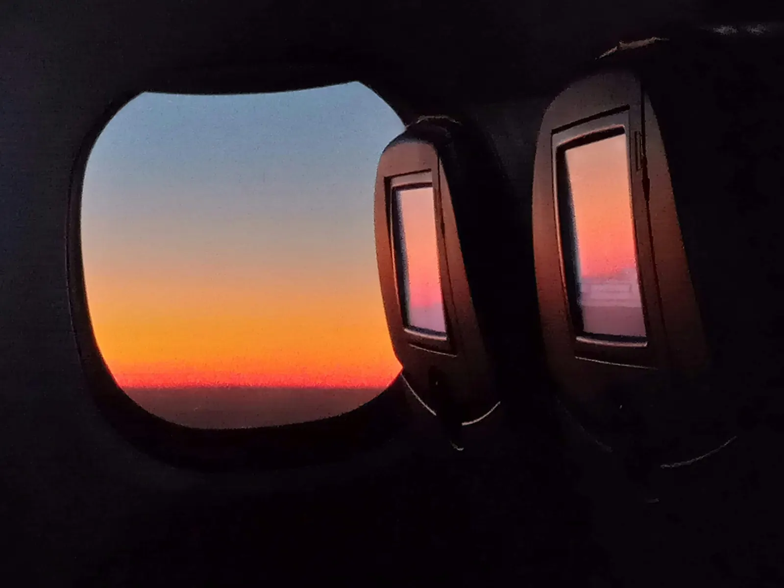 Vista da janela de um avião ao pôr do sol